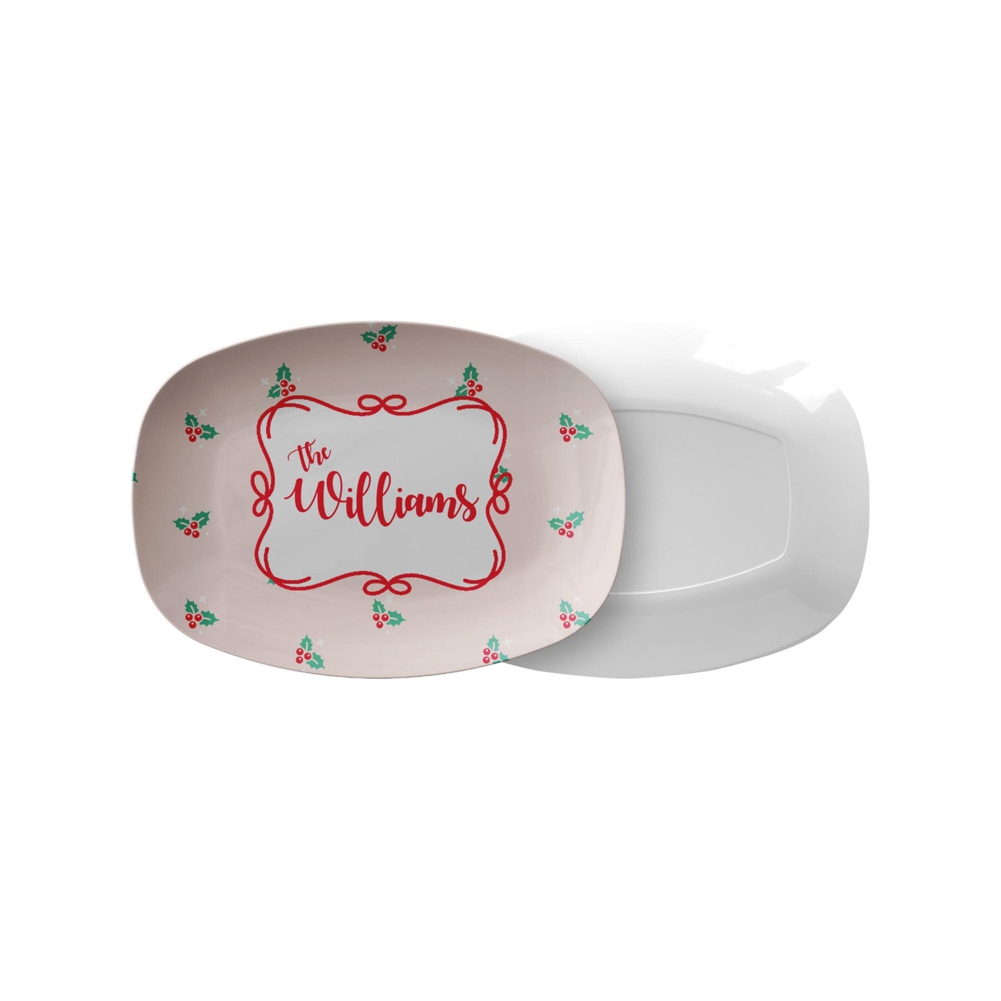 personalized Christmas serving platter with pink background, holly sprigs and custom family name The Williams on marble countertop with tea towel and lemon