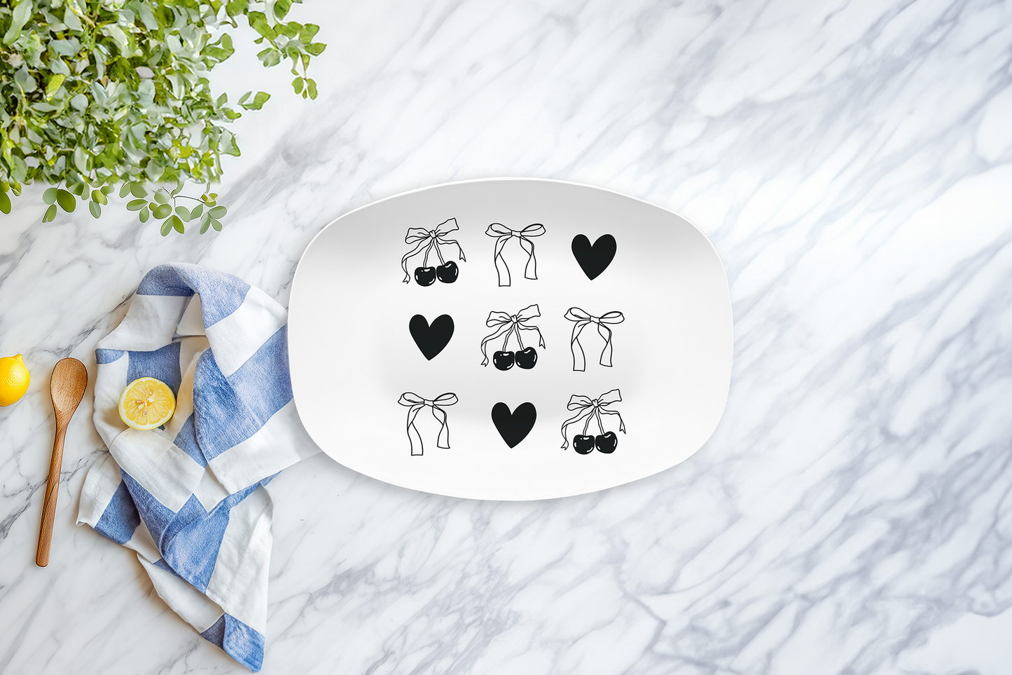Decorative plate with bow and heart designs on a marble surface with a lemon and towel.