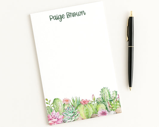 Notepad with cactus design and pen on a white background
