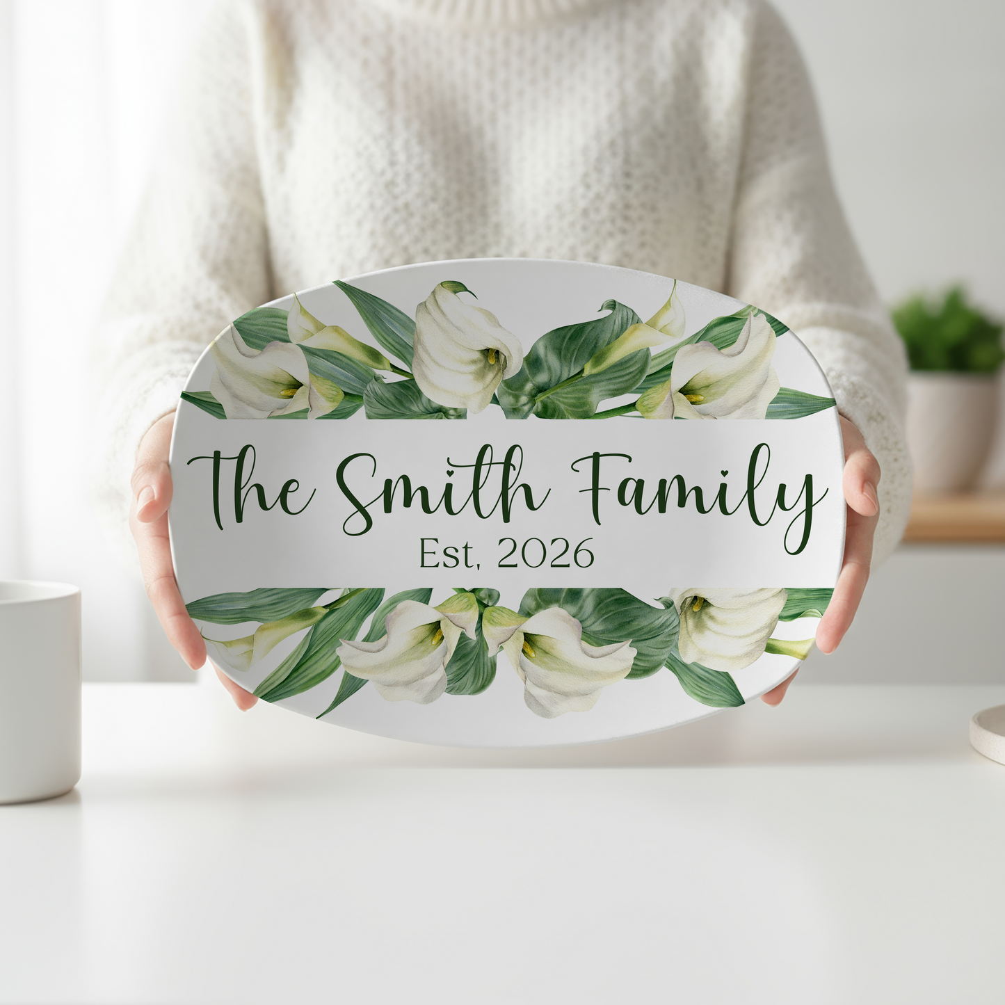 Personalized oval serving platter featuring elegant white calla lilies, lush green leaves, custom family name, and optional established year. Custom floral serving tray perfect for weddings, housewarming gifts, entertaining, and personalized kitchen décor.