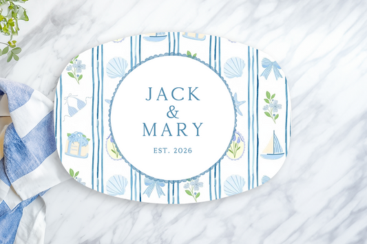 Personalized oval serving platter featuring elegant blue coastal stripes with nautical accents including sailboats, seashells, bows, and florals. Customized with the couple's names and established year, this timeless serving tray is perfect for beach house entertaining, weddings, anniversaries, and coastal home décor.
