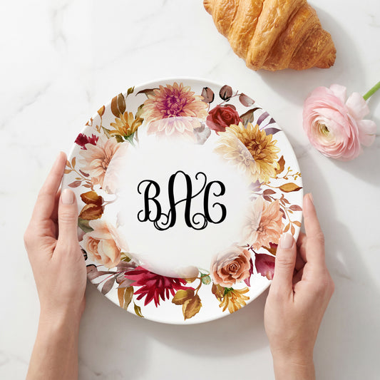 Personalized white plate featuring a watercolor wreath of autumn flowers in burgundy, rust, cream, and golden tones surrounding a custom three-letter monogram, perfect for Thanksgiving, fall entertaining, and seasonal home décor.