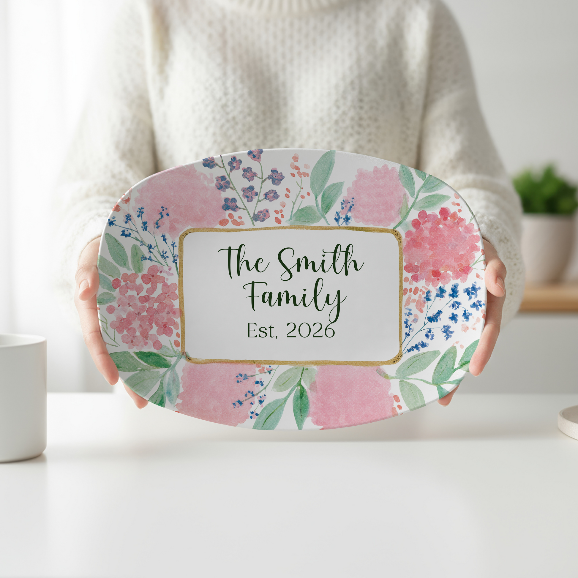 Personalized oval serving platter featuring watercolor pink hydrangeas, wildflowers, greenery, and an elegant gold-accented frame customized with a family name and established year. Perfect for weddings, housewarming gifts, entertaining, and floral kitchen décor.