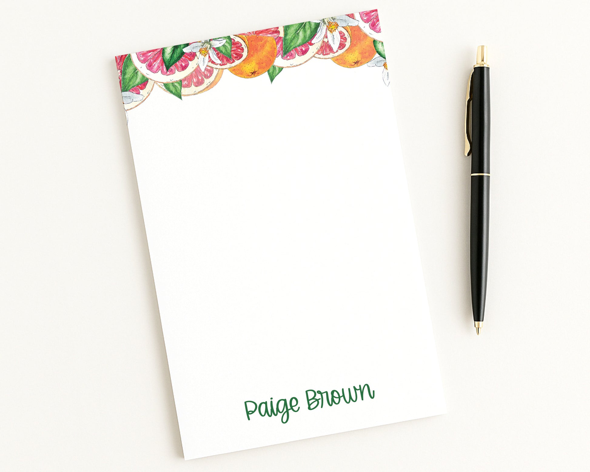 Notepad with fruit border and pen on a white background