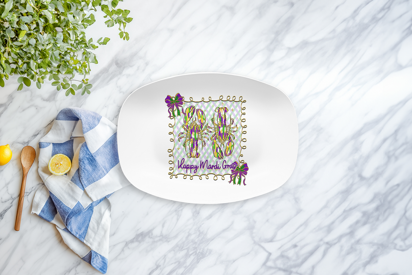 Decorative plate with floral design and Happy Mardi Gras text on a marble surface with a lemon and towel.