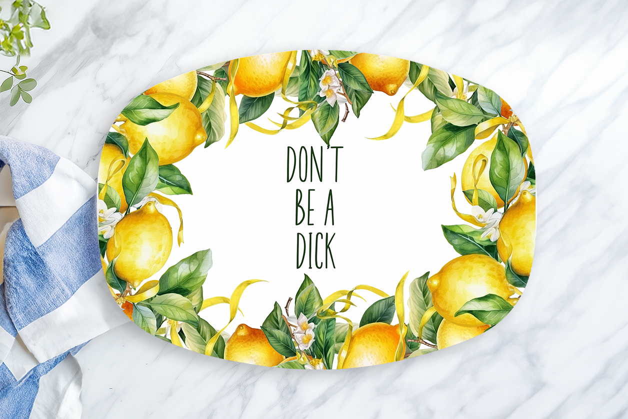 Decorative plate with lemons and text on a marble surface with a towel and lemon.