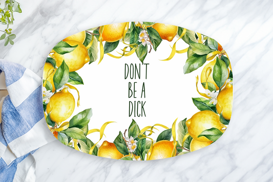 Decorative plate with lemons and text on a marble surface with a towel and lemon.