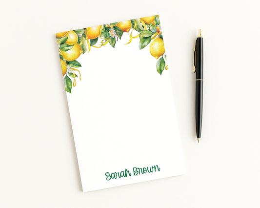 Notepad with lemon design and pen on a white background