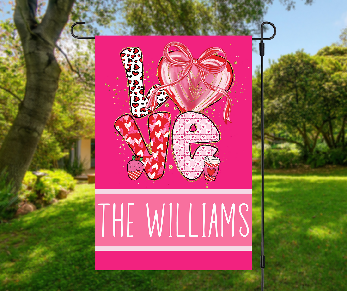 personalized Valentines garden flag with bright pink LOVE letters, heart and bow design, custom family name THE WILLIAMS on hot pink background hanging on garden stand