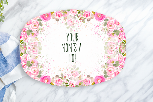 Floral-patterned cutting board with text on a marble surface with a towel and lemon.