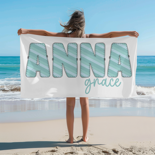 Blue and teal striped name on a beach towel