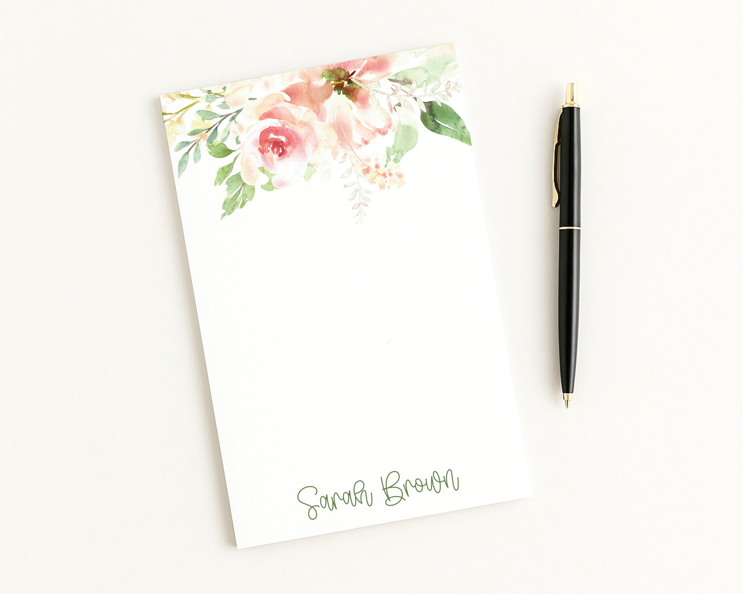 Floral notepad with a pen on a white background