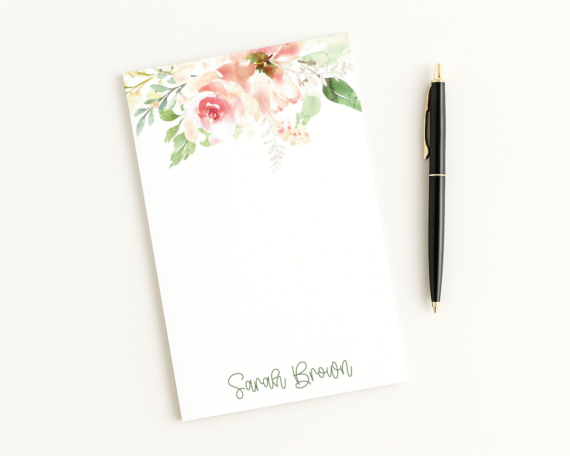 Floral notepad with a pen on a white background