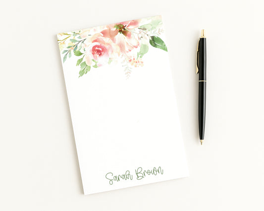 Floral notepad with a pen on a white background