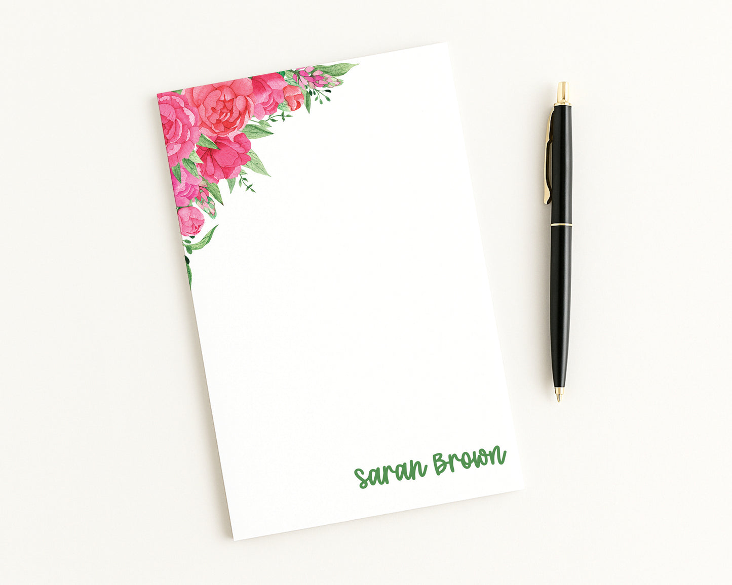 Floral notepad with a pen on a white background