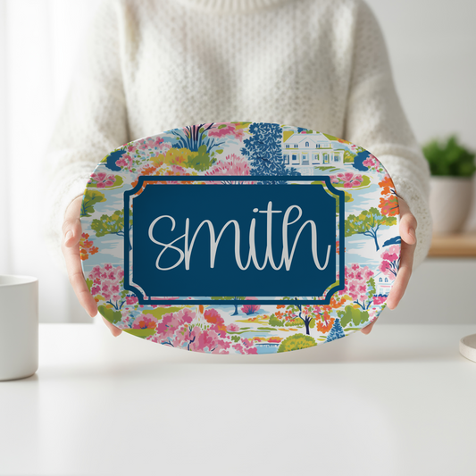 Personalized oval serving platter featuring a colorful preppy landscape with blooming gardens, charming estate scenery, a navy custom nameplate, and personalized family name. Decorative serving tray perfect for weddings, housewarming gifts, entertaining, and stylish kitchen décor.