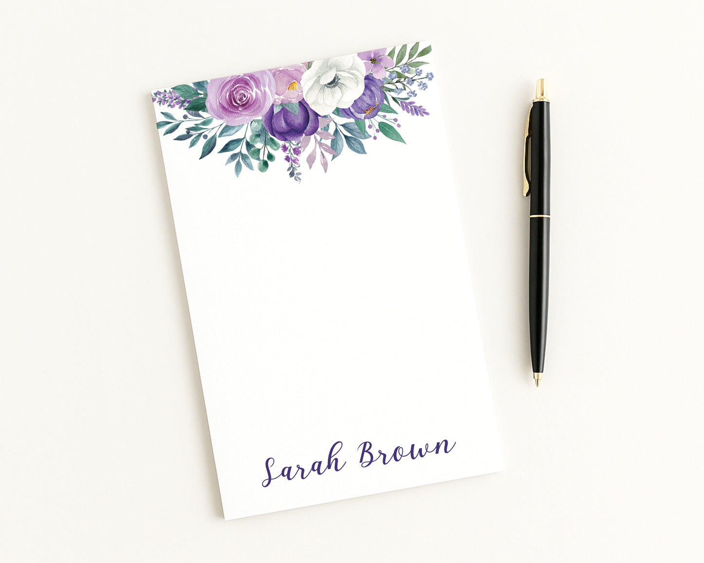 Floral notepad with a pen on a white background