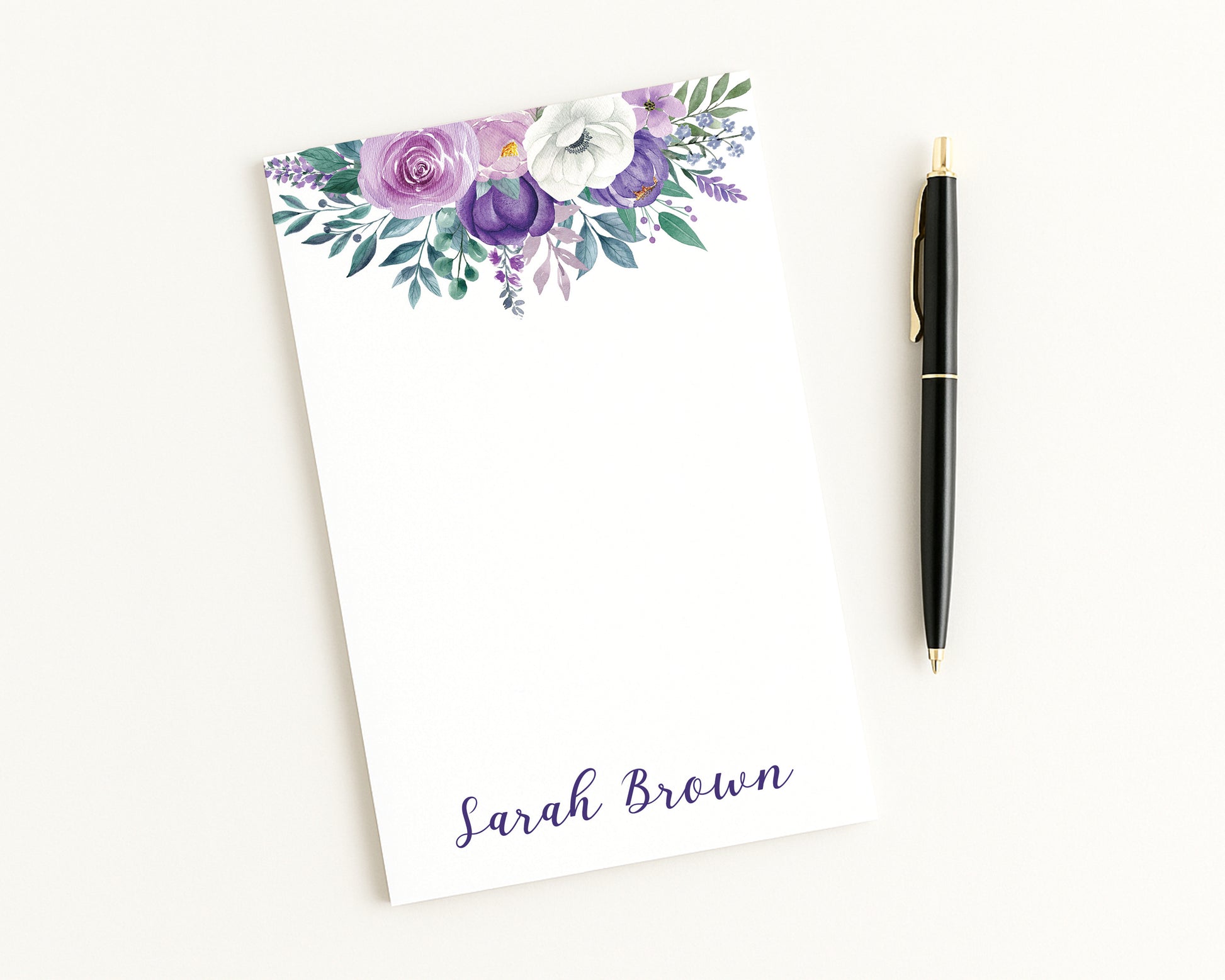 Floral notepad with a pen on a white background