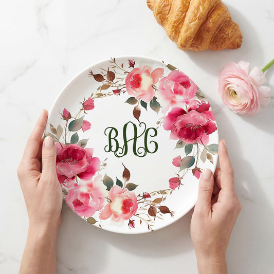 Personalized white plate featuring a vibrant watercolor wreath of pink roses and botanical greenery surrounding a custom three-letter monogram, creating an elegant floral plate perfect for weddings, housewarmings, Mother's Day, and personalized home décor.