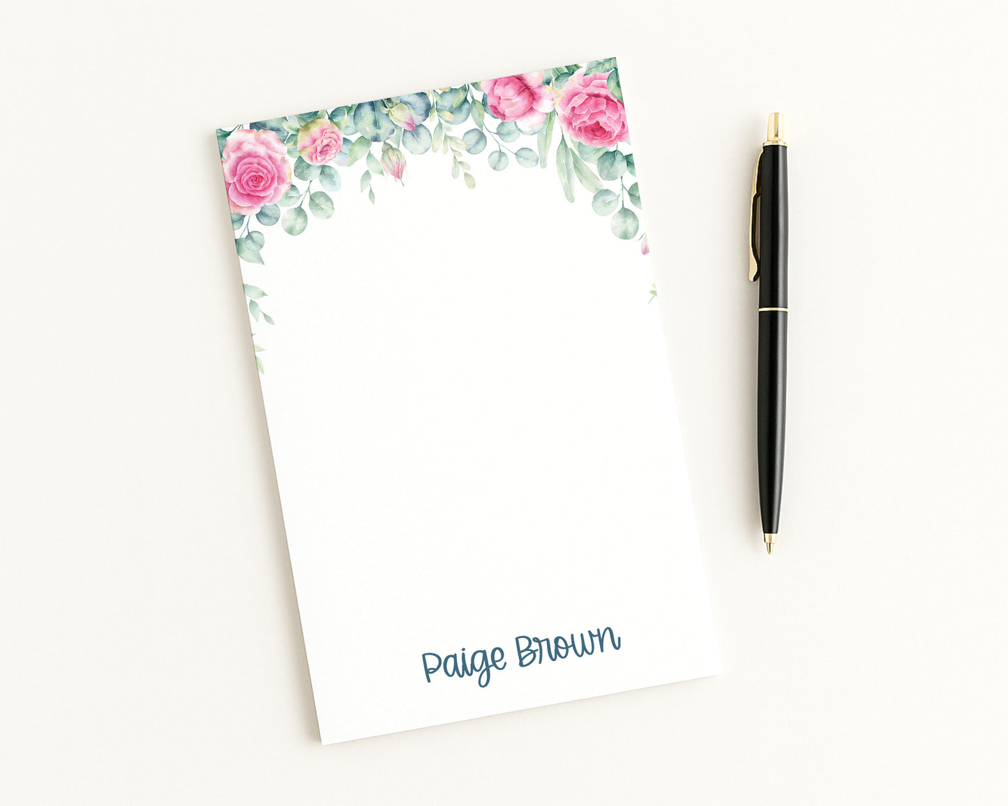 Floral notepad with a pen on a white background