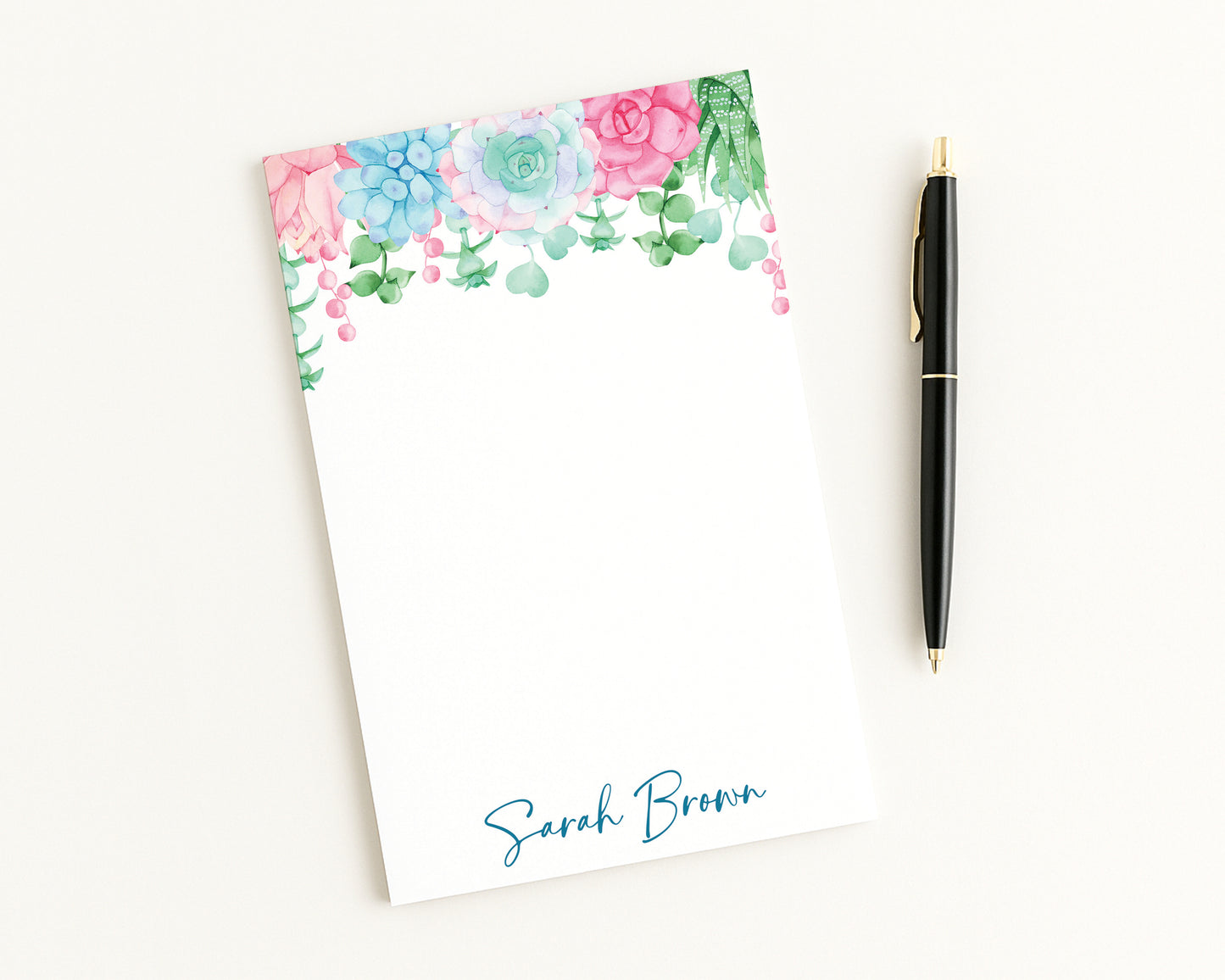 Floral notepad with a pen on a white background
