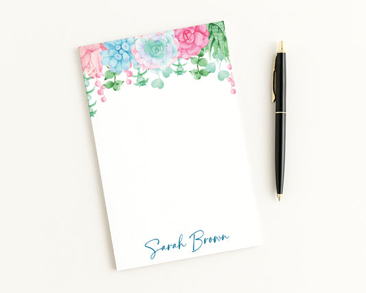 Floral notepad with a pen on a white background