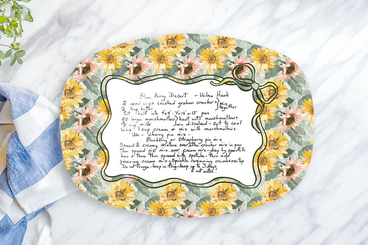 Decorative plate with floral design and text on a marble surface with a lemon and cloth.