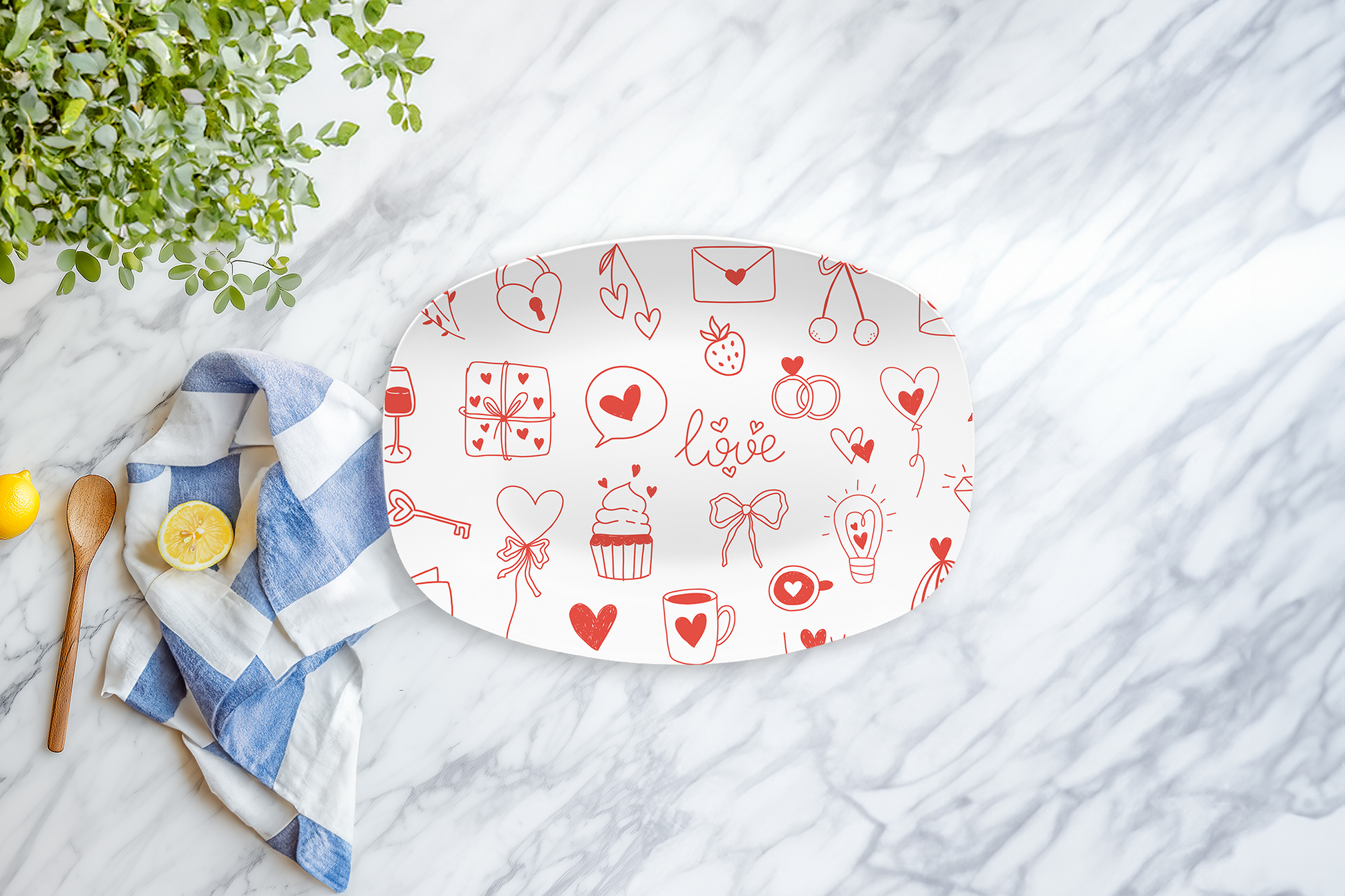 Decorative plate with red valentines day illustrations on a marble surface with a towel and lemon.