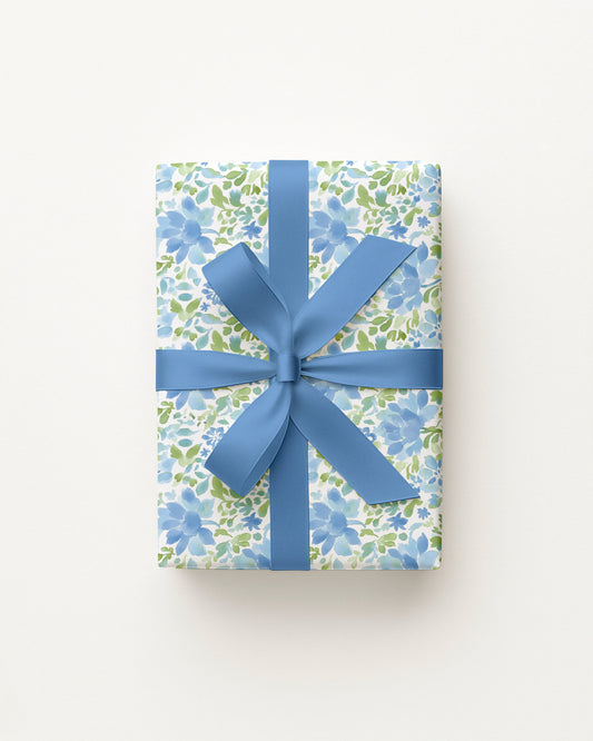 Gift box with floral pattern and blue ribbon on a white background