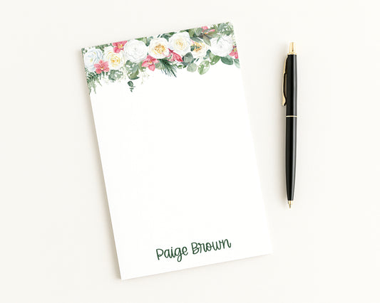Floral notepad with a pen on a white background