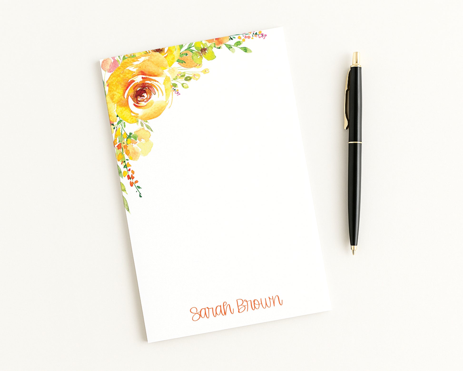 Floral notepad with a pen on a white background